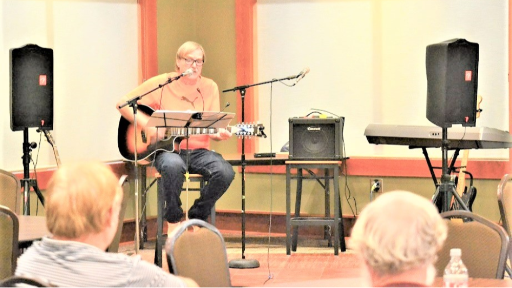 Person playing the guitar at an Open Mic night