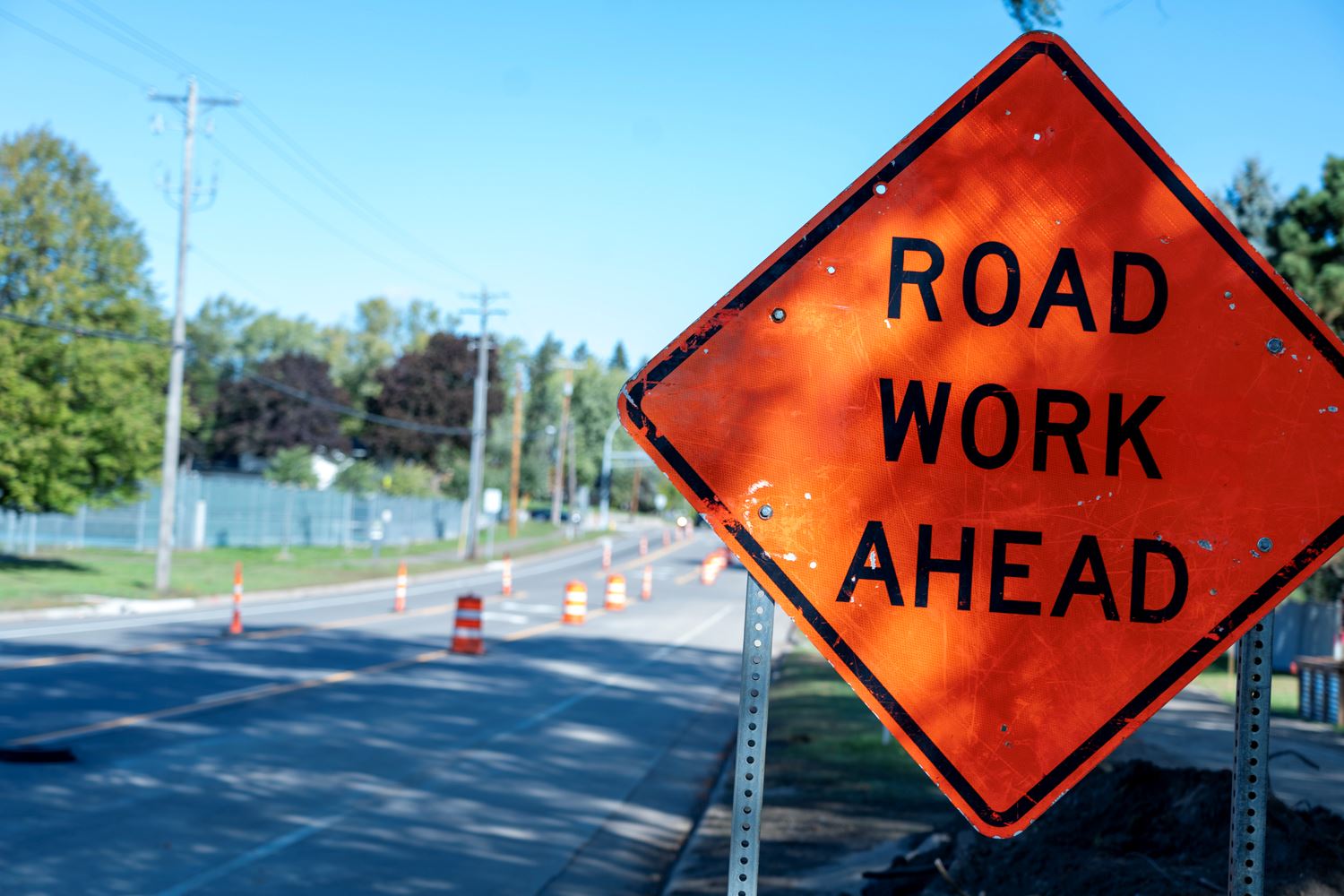 An orange sign reads Road Work Ahead.