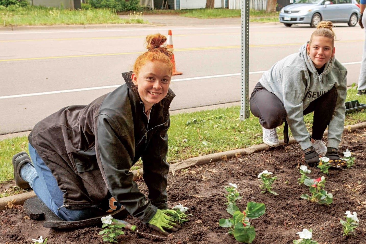 Volunteers Sophie and Olivia Martin plant flowers at Blooming Boulevard event at Central Park.