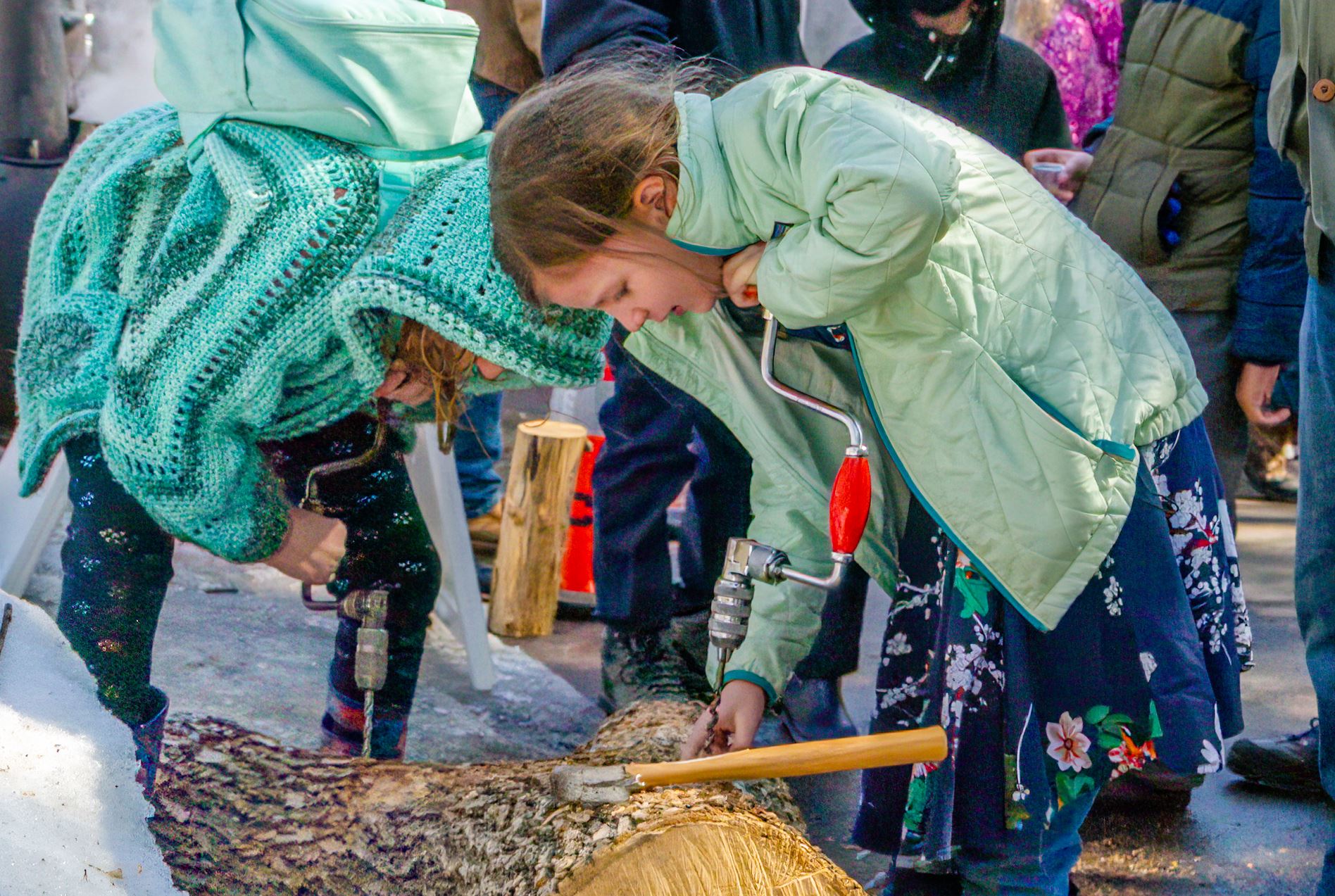 Two girls using hand braces to practice drilling tap holes